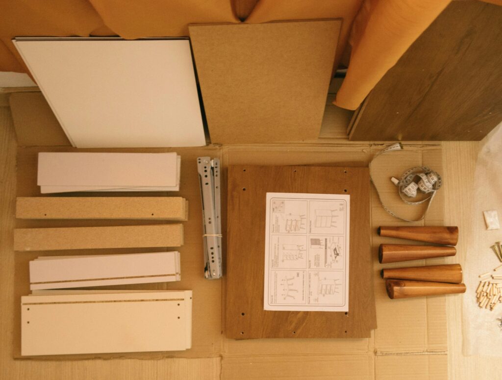 Flat lay of a DIY furniture assembly kit with instructions and tools.